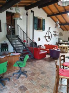 明乔河畔的瓦雷奇奥科尔特阿提利亚农家乐的一间带红色沙发的客厅和楼梯