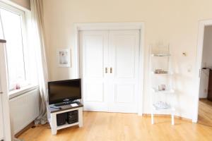奥利希Hus Lintje的一间带电视和白色门的客厅