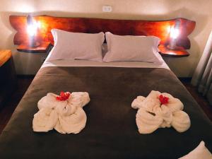 圣安东尼奥-杜皮尼亚尔Pousada Recanto das Marias的酒店客房的床上有两条毛巾