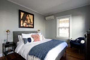 哈德逊Nest Hudson的卧室配有一张床,墙上挂有绘画作品
