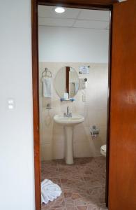 切图马尔Hotel & Suites Arges - Centro Chetumal的一间带水槽、镜子和卫生间的浴室