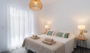 福恩吉罗拉Sur Suites La Dorada的白色卧室,配有带毛巾的床