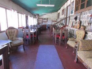 圣地亚哥Hostería Baños Morales的用餐室设有桌椅和窗户。