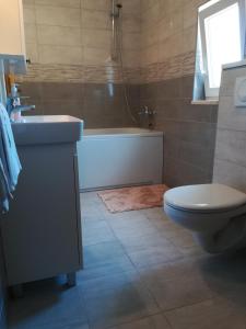 维甘Apartmani Nedjeljka的带浴缸、卫生间和盥洗盆的浴室