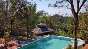 额布里Lakeview Lodge Ngapali的一座游泳池,其凉亭位于树旁