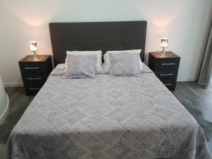 丰沙尔Funchal Paradise的一间卧室配有一张带2个床头柜的大床