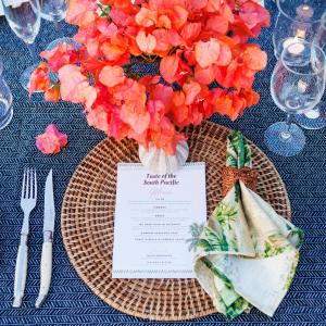 卢甘维尔奥雷岛度假村的一张桌子,上面有一块带橘子花的花瓶