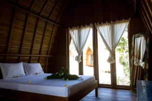 龙目岛库塔Majango Bungalows的一间卧室设有一张床和一个大窗户