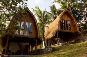 龙目岛库塔Majango Bungalows的山丘上茅草屋顶的房子