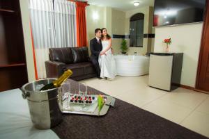 阿雷基帕Hotel La Casona Del Olivo Arequipa的站在客厅里的一名新娘和新郎