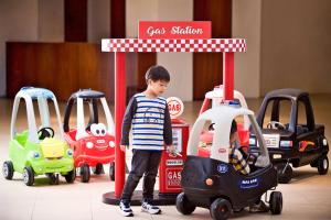 Fushi太鲁阁晶英酒店的一只小男孩站在玩具车的标志下