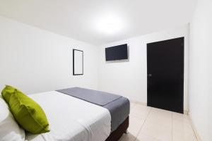 波哥大Ayenda 1045 Boutique Aeropuerto的卧室配有一张床,墙上配有电视。