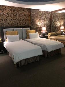 新竹新竹水晶旅馆的酒店客房,设有两张床和一张沙发