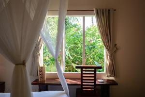 芽庄The Trang Villas的卧室设有窗户、木桌和椅子
