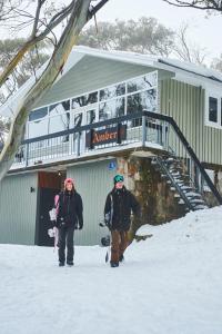 布勒山布勒山琥珀旅馆的两个人在大楼前的雪中行走