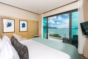 攀瓦海滩My Beach Resort Phuket的一间卧室设有一张大床和一个大窗户