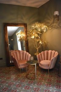 锡内乌Ten Mallorca - Adults Only的一间设有两把椅子、一张桌子和一面镜子的房间