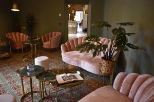 锡内乌Ten Mallorca - Adults Only的客厅配有粉红色的椅子和植物桌子
