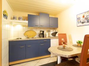 卑尔根Fewo Prey的一间小厨房,配有蓝色橱柜和一张桌子