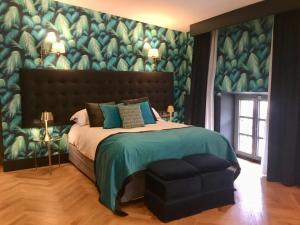 锡内乌Ten Mallorca - Adults Only的一间卧室配有一张带绿色壁纸的大床