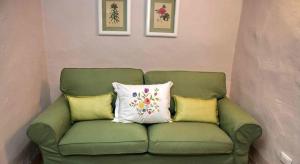 潘札诺安蒂科基安蒂酒店的绿色沙发,配有三个枕头