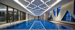 乌鲁木齐Wanda Vista Hotel Urumqi的一座大游泳池,位于一座大字楼内
