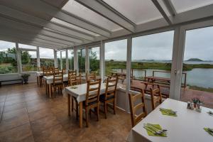米湖迪姆波贾尼宾馆的用餐室设有桌椅和窗户。