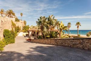 迈阿密普拉特亚Cala Cristal by Pierre & Vacances Premium的海边石墙旁的走道