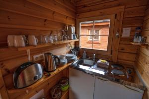 米湖迪姆波贾尼宾馆的小屋内的厨房设有水槽和窗户