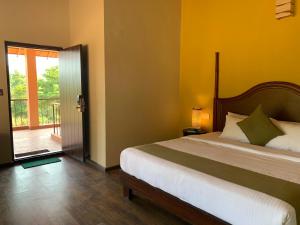 瑟格莱什布尔Machaan Plantation Resort, Sakleshpur的一间卧室设有一张床,并有通往阳台的门