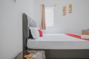 班达楠榜RedDoorz Syariah near Pahoman Stadium Lampung的一间卧室设有一张床和一个窗口