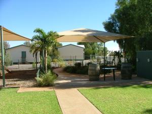 罗克斯比唐斯Discovery Parks - Roxby Downs的一个带遮阳伞和桌子的庭院