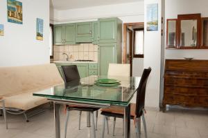 瓦雷多利亚Casa di Rita的厨房配有绿色橱柜和玻璃桌椅