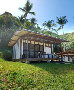 爱妮岛Duli Beach Resort的草场上带屋顶的小房子