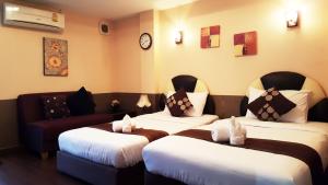 曼谷拜客套房旅馆的酒店客房,设有两张床和一张沙发