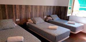 萨拉戈萨Pensión La Estrella的一间设有三张床和枕头的客房