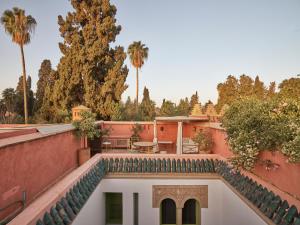 马拉喀什Riad Volubilis的享有棕榈树房屋庭院的景色