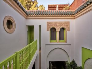 马拉喀什Riad Volubilis的一座带楼梯和绿色栏杆的房子