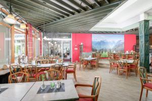 迈埃勒芬迈埃勒芬度假酒店的一间带桌椅和壁画的餐厅