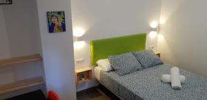 萨拉戈萨Pensión La Estrella的一间小卧室,配有一张床和一个绿色的床头板