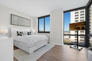 泽西市Global Luxury Suites Downtown Jersey City的卧室设有白色的床和大窗户