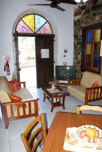 卡洛帕尼亚伊奥蒂斯ATRATSA Mountain Suites的客厅配有桌椅和电视。