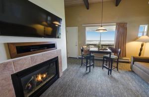 亚查茨Fireside Motel的客厅设有壁炉、桌子和椅子