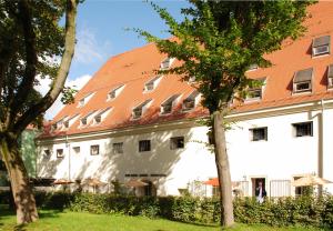 雷根斯堡奥费安德斯塔德尔酒店的一座白色的大建筑,有红色的屋顶