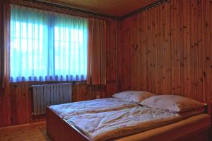 维托韦Dom u Małgosi的木制客房的一张床位,设有窗户