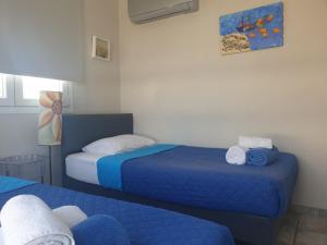 皮尔瓦利亚Periyiali Beach Sunset Suite A7的一间设有两张蓝色床单的床的房间