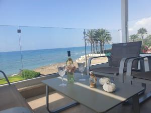皮尔瓦利亚Periyiali Beach Sunset Suite A7的一张桌子,上面放着两杯酒和一瓶葡萄酒