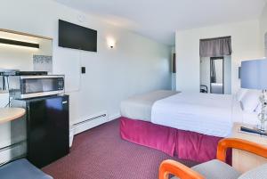 索科The Saco Motel的酒店客房设有一张大床和一张桌子。