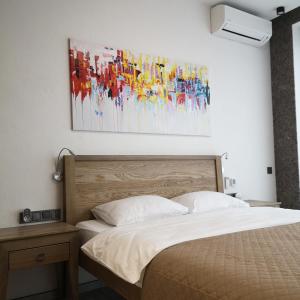第聂伯罗ACCOMMODO192的卧室配有一张床,墙上挂有绘画作品