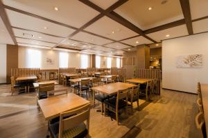 宇都宫Hotel Route-inn Utsunomiya Yuinomori -Lightline Yuinomori Nishi-的用餐室配有木桌和椅子